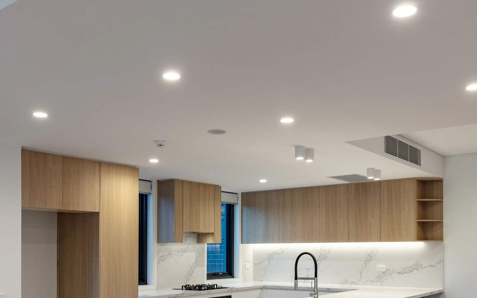 A kitchen and living area lit with new LED downlights