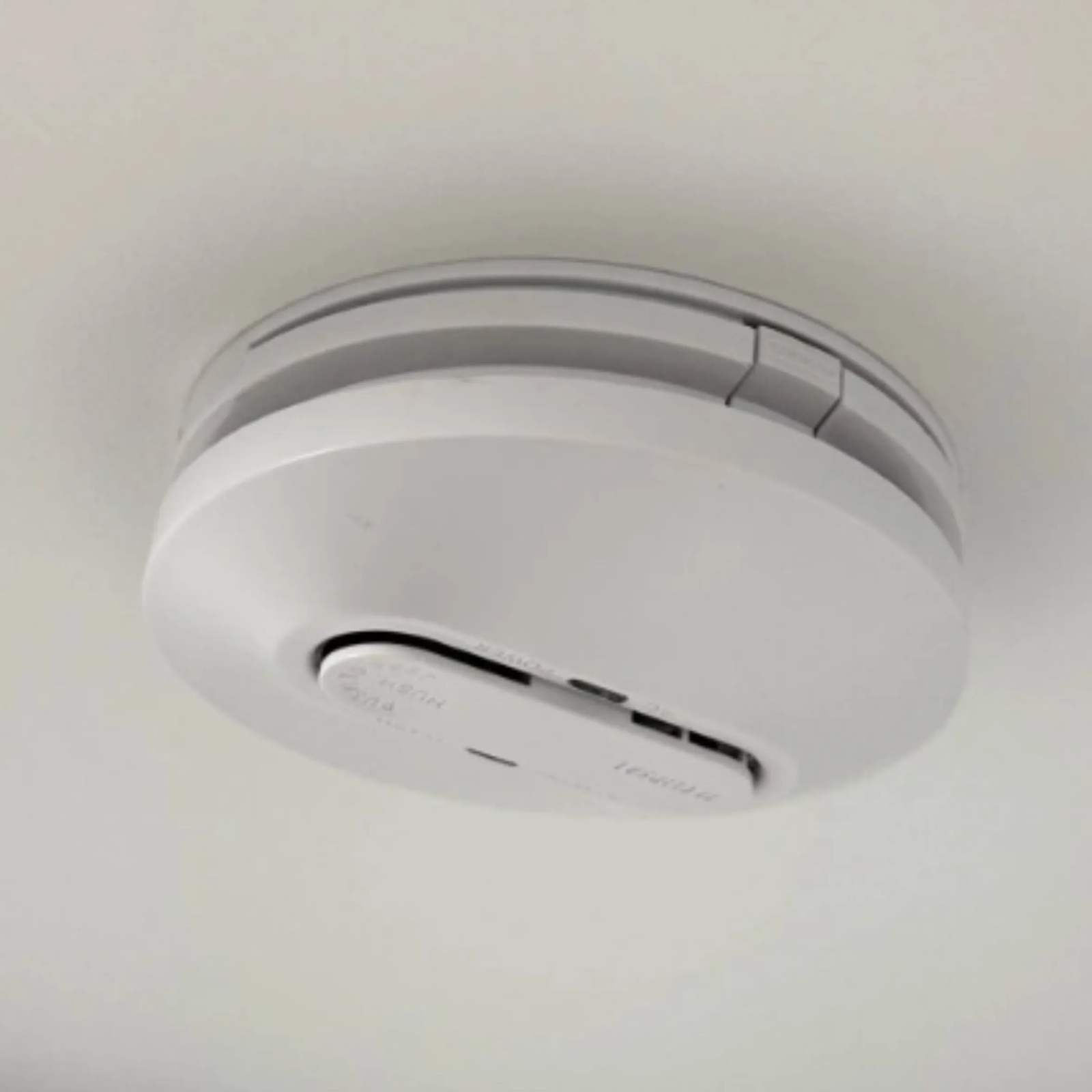 A new 240 V smoke alarm fitted to the ceiling