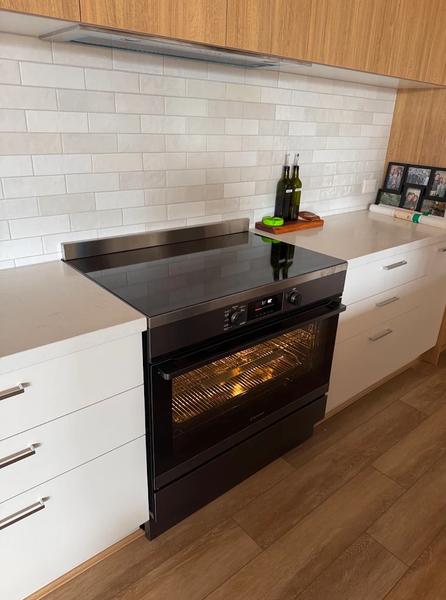 A 90 cm freestanding induction stove installed in a kitchen